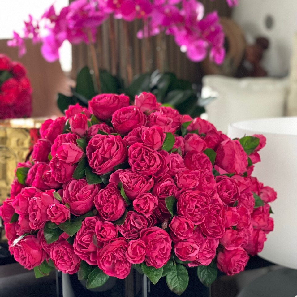 Roses anglaises rose foncé dans un vase en verre noir
