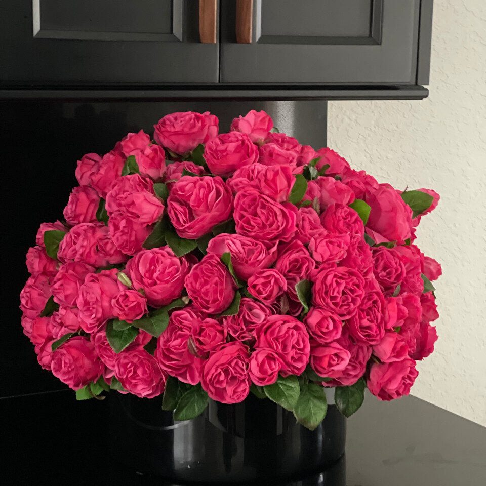 Roses anglaises rose foncé dans un vase en verre noir