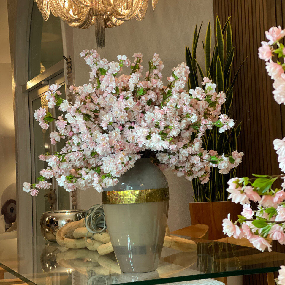 Vase de déesse avec des fleurs de cerisier roses