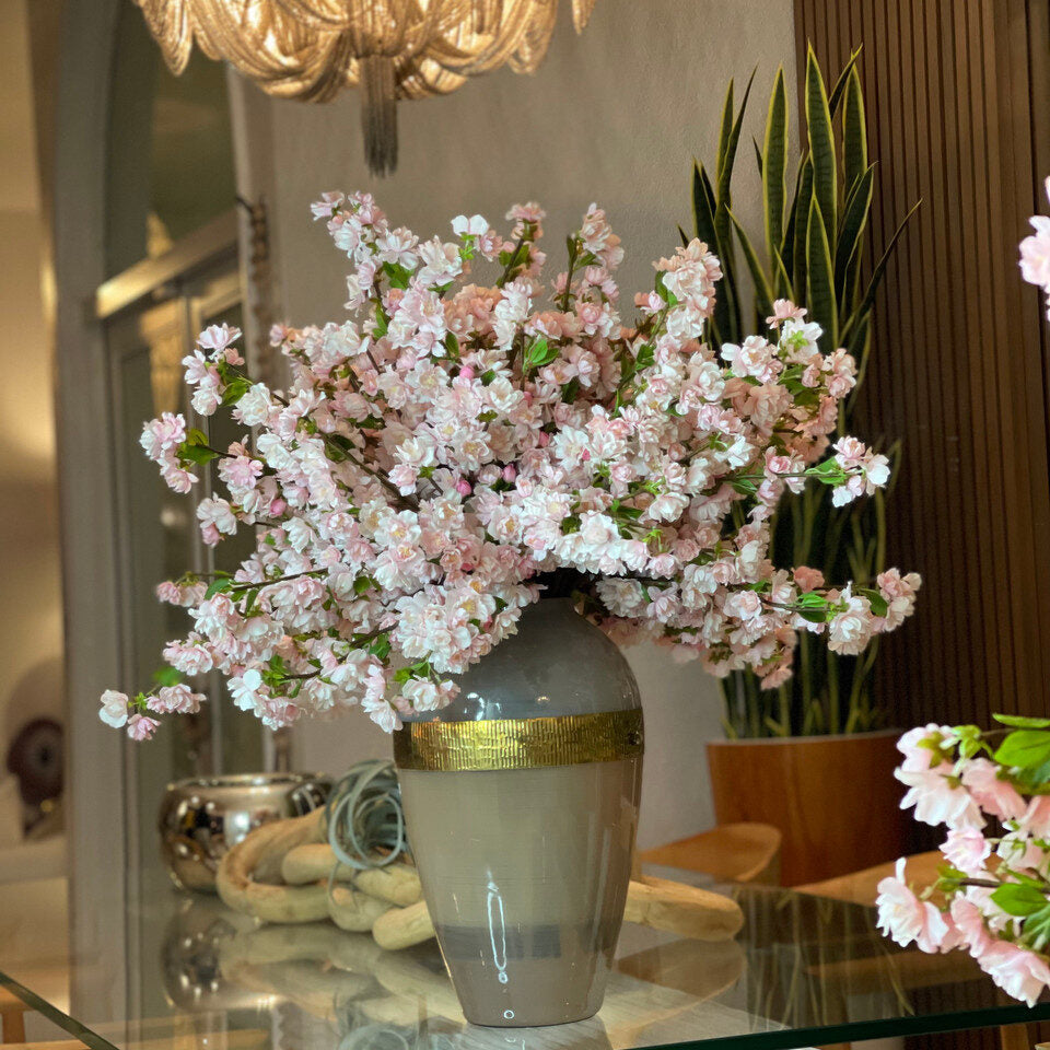 Vase de déesse avec des fleurs de cerisier roses