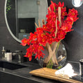 Cymbidiums rouges dans un vase en forme de lune