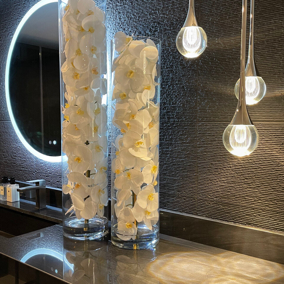 Cylindre de verre contenant des orchidées Phalaenopsis blanches