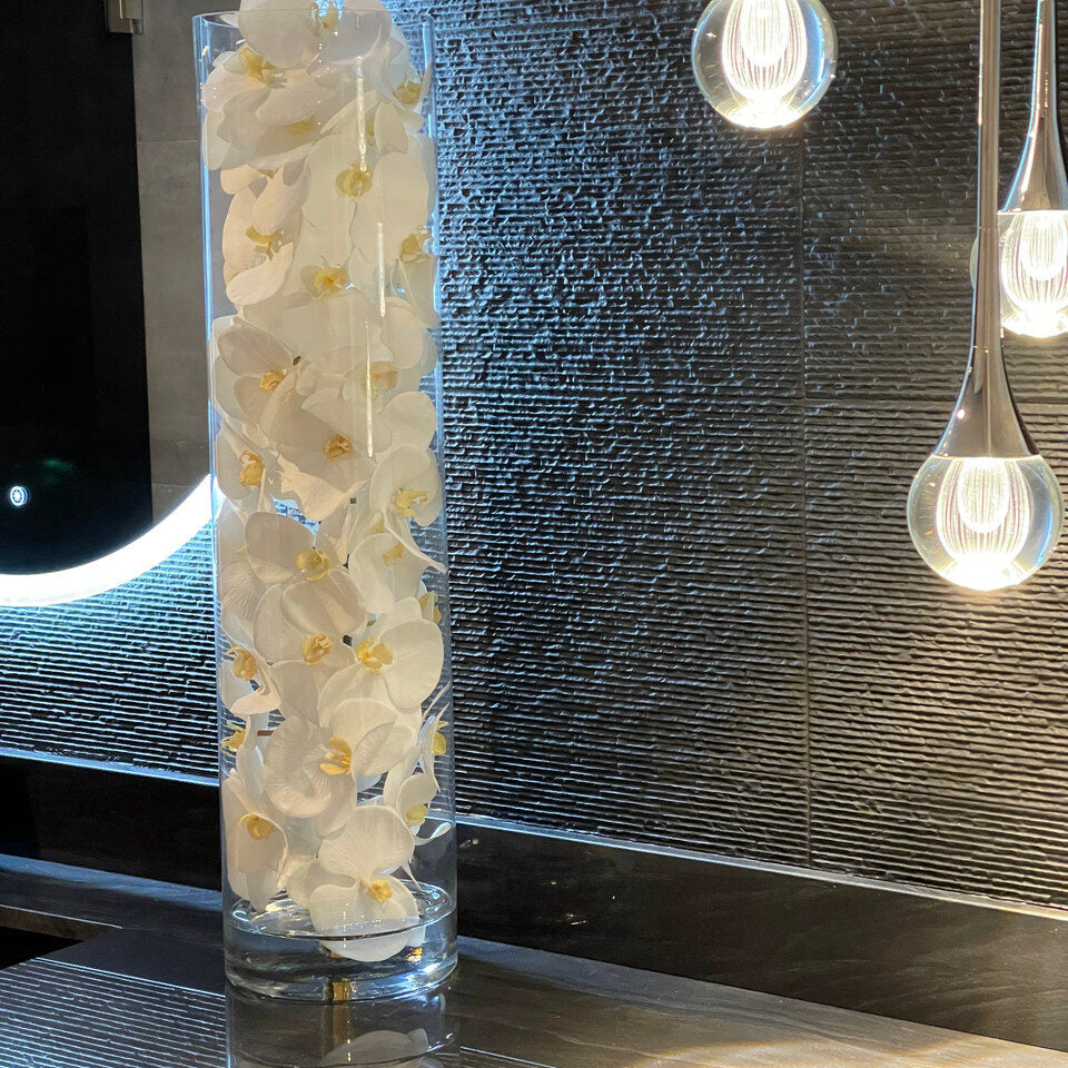 Cylindre de verre contenant des orchidées Phalaenopsis blanches