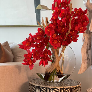 Cymbidiums rouges dans un vase en forme de lune