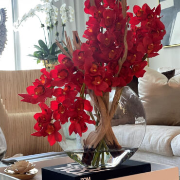 Cymbidiums rouges dans un vase en forme de lune